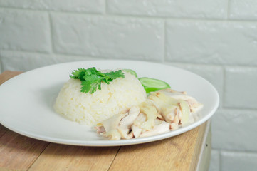 Chicken rice with dipping sauce and soup placed on a wooden table