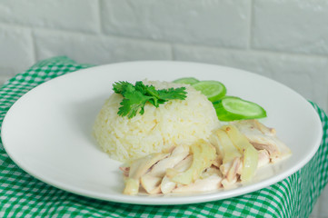 Chicken rice with dipping sauce and broth laid on a green tablecloth