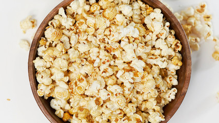 photo sweet popcorn on a white background wooden bowl top view