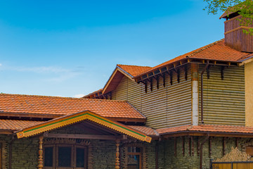 Roofs of buildings with red tiles against the blue sky. Wooden house.