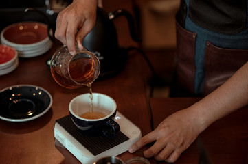Fototapeta na wymiar Barista pouring coffee into a cup