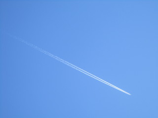 The effect of a plane flying in the clear blue sky