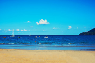 Beach with golden sand and clear water. Wave in the sand and blue sky. Beach with blue ocean and sky. Summer travel concept.