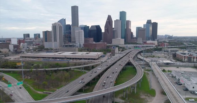 Aerial view of traffic on freeway near downtown Houston on a cloudy day during sunset. This video was filmed in 4k for best image quality.