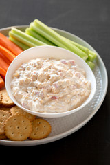 Homemade Southern Pimento Cheese Dip with carrots, celery and crackers, low angle view. Close-up.