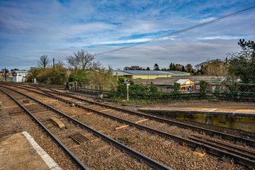Fototapeta premium Empty railway tracks captured from a quiet rural train station