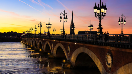 Pont de Pierre bridge in Bordeaux at sunset as the night sky scene