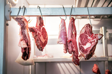 Pieces of fresh beef hanging in refrigerator