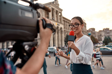 News that works. TV reporter presenting the news outdoors. Journalism industry, live streaming...