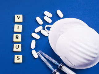 Fototapeta premium Viral disease treatment and prevention concept. Epidemic danger prevention. Treatment concept with masks, syringes and antibiotic pills on blue background