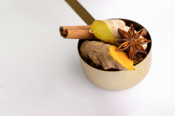 Ingredients  for making Ayurvedic beverage Golden Milk ginger, turmeric, anise, clove and cinnamon spices on white background.