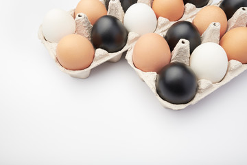 Eggs of different colors in cardboard boxes. Black, white and brown chicken eggs.
