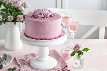festive pink cake on white cake stand decorated with fresh roses for Valentines Day