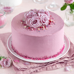 Obraz na płótnie Canvas festive pink cake on white cake stand decorated with fresh roses