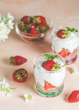 Cream strawberry. Glass bowl of strawberries with whipped cream and mint. Jasmine flowers. Concrete surface, copy space for you text.