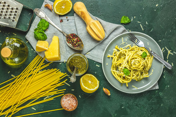 Gray plate of  Italian traditional perciatelli pasta by genovese pesto sauce served with...