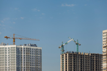 Construction site with cranes against the blue sky