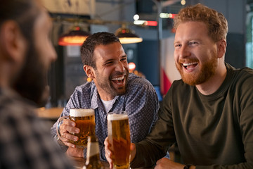 Friends enjoying draft beer at pub - Powered by Adobe