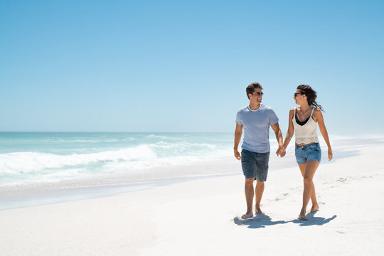 Young happy couple walking on beach