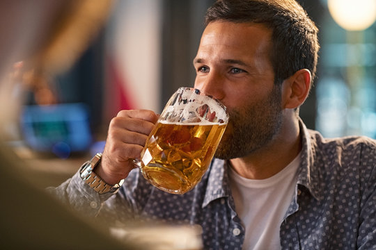 Man drinking a pint of draft beer - Powered by Adobe