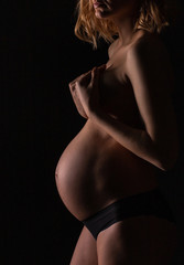 close-up vertical photo of a pregnant woman's belly