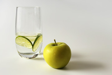 Healthy life, healthy breakfast, healthy snaсk, gum, glass of water with lime, apple, green apple