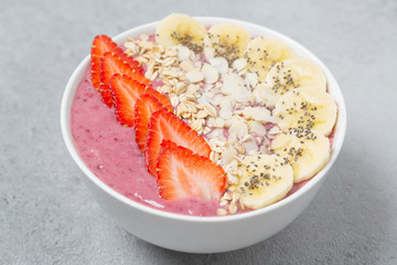 Smoothie bowl with chia seeds, muesli, strawberries, banana  and almond flakes. Healthy breakfast bowl.