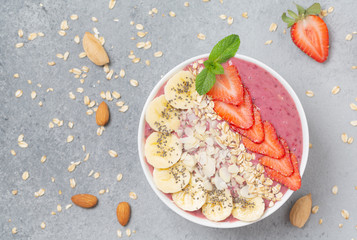 Smoothie bowl with chia seeds, muesli, strawberries, banana  and almond flakes. Healthy breakfast bowl.