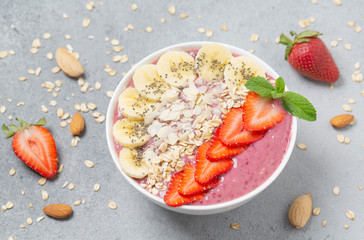 Smoothie bowl with chia seeds, muesli, strawberries, banana  and almond flakes. Healthy breakfast bowl.