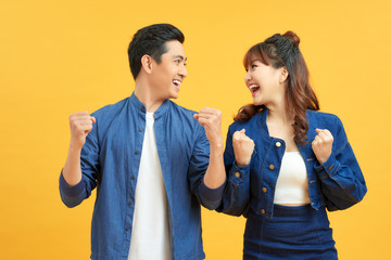 Thrilled man and woman with open mouth positive surprise isolated on yellow background