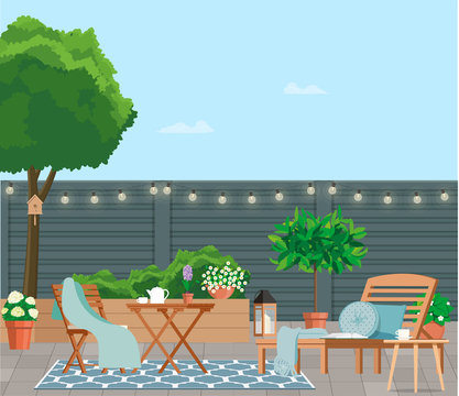 Back patio with garden furniture on a background of green plants.