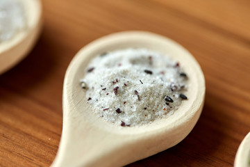 food, culinary and unhealthy eating concept - close up of wooden spoon with flavored salt