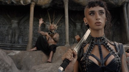 Adventure scene.Girl in a tomb raider style with sword near Tattooed masked skull ethnic pagan shaman at ancient temple