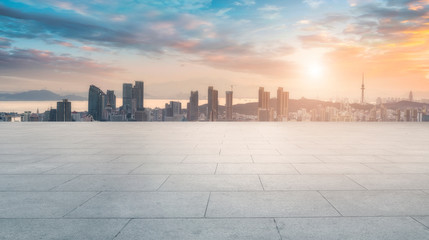 Empty square floor tiles and Qingdao urban architecture skyline..