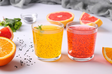 Trendy tropical orange and grapefruit juice with basil seeds or falooda seeds or tukmaria in glass on white background