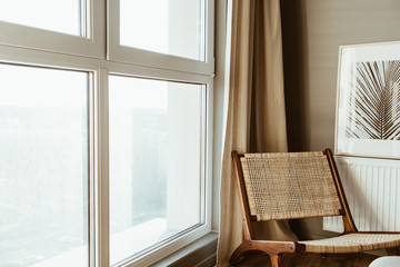 Modern interior design concept. Stylish rattan wooden chair, window, curtains. Minimal Scandinavian apartment.
