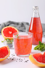 Healthy drink grapefruit with basil seeds or falooda seeds or tukmaria in a bottle and glass on a white background, Vertical format