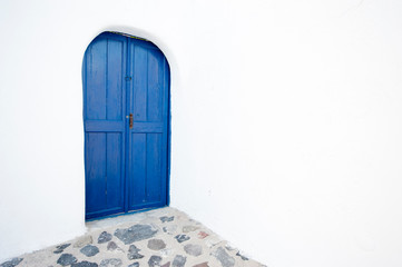 Mediterranean blue door with rounded doorway and Greek white stucco walls 