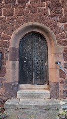 Iron studded wooden door to an old church.  The wood is weathered with age