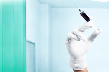 Doctor man in protective gloves holding a syringe