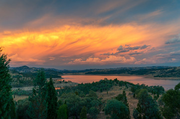 Aerial view of dramatic sunset over river valley with distant mountains