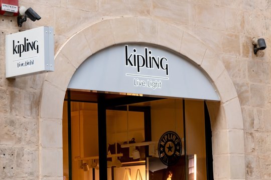 The entrance door to the outlet of the Kipling company with a Live Light slogan which sells bag and other luxurious accessories