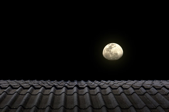 The top of the house roof in the night with the bright moon background. 