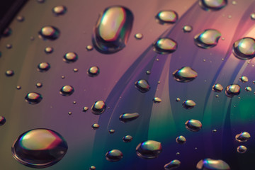 Close up beautiful abstract multi colored water drop of holographic effect. Background pattern for...