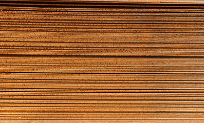 Racks of metal profiles. Metal is stored in an open warehouse. Wet and rusty on the street. Old grunge background made of rusty iron for shooting flatleys on the table