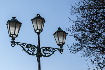 Fototapeta na wymiar Vintage street lamp on blue sky background and tree in spring