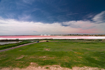 Obraz premium Panoramic view of the ponds and salt flats from the ramparts of the walls, the fortified city of Aigues Mortes, in the Camargue France.