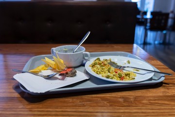 remnants of food on the tray, the remains of lunch. Rice with vegetables on a plate
