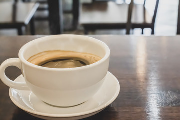 Hot coffee cup of black,coffee on wooden table in the morning.