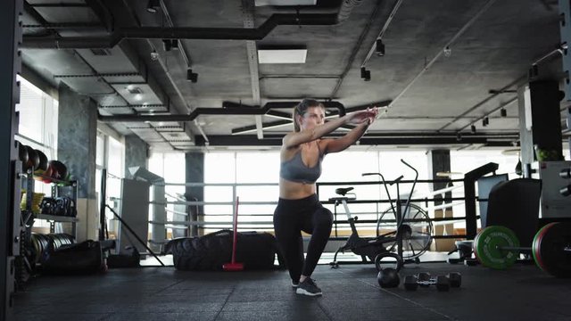 Tracking wide shot three quarter angle of fit young woman doing crossover lunges during cross training in gym